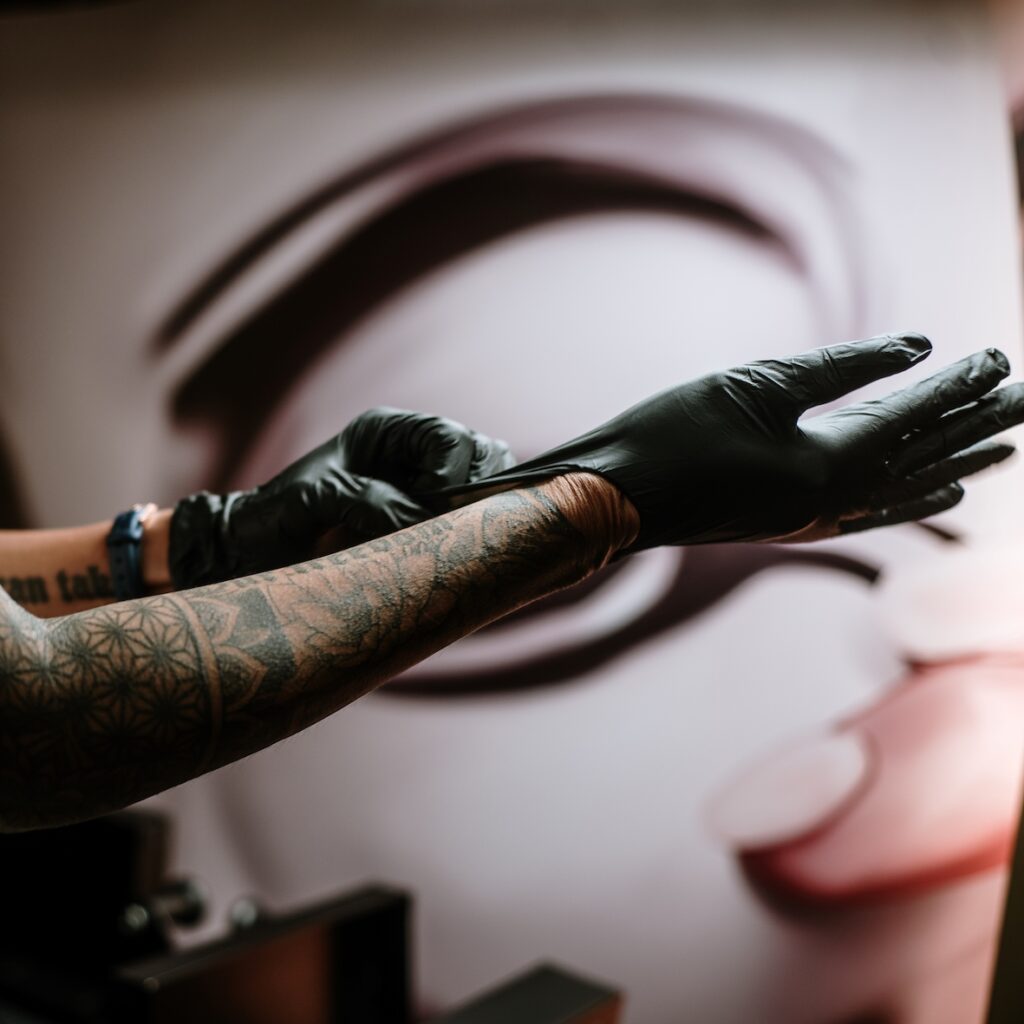 A Canggu Ink Club tattoo artists putting gloves on